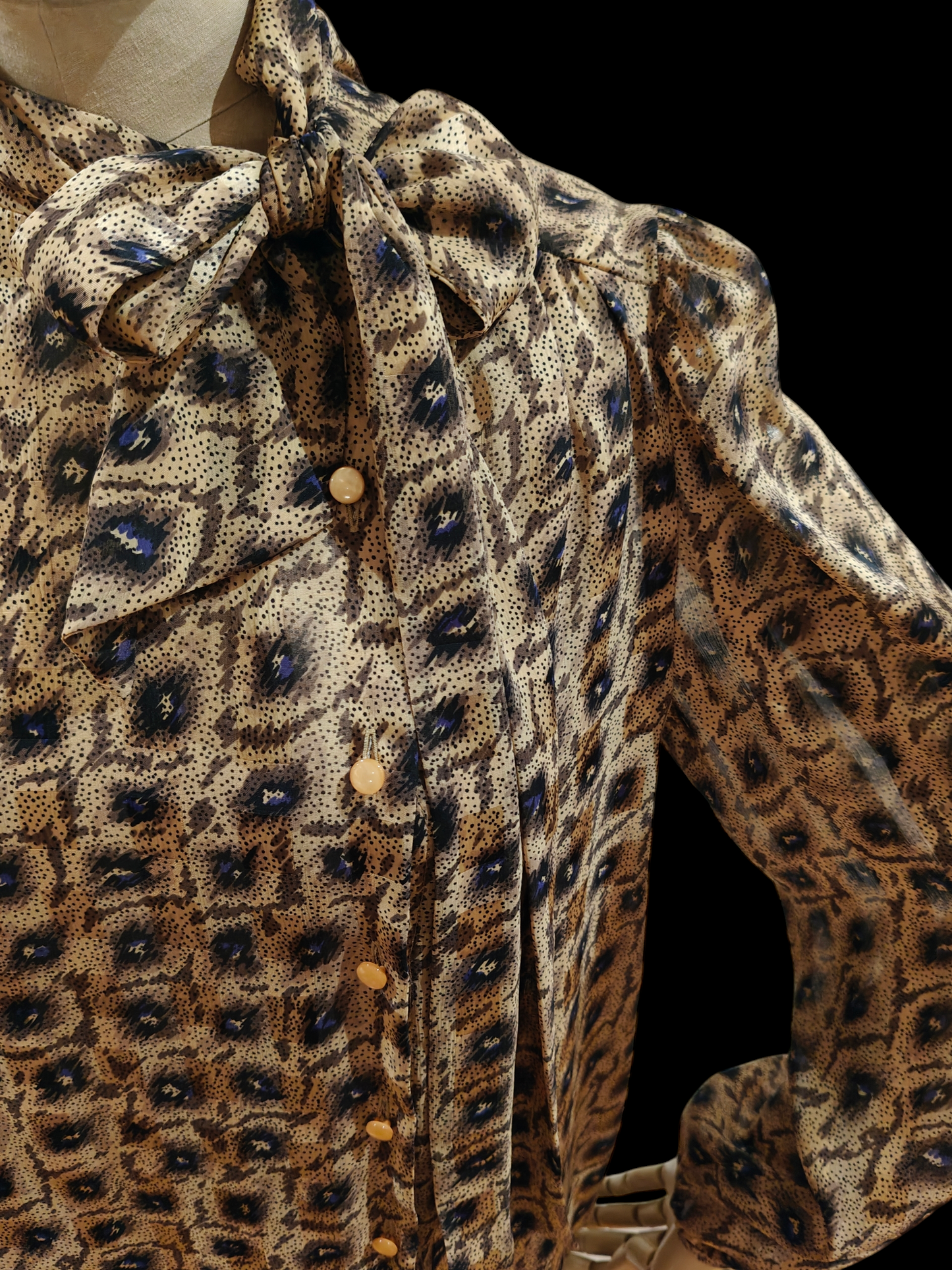 Close-up of a patterned blouse with a collar and buttons.
