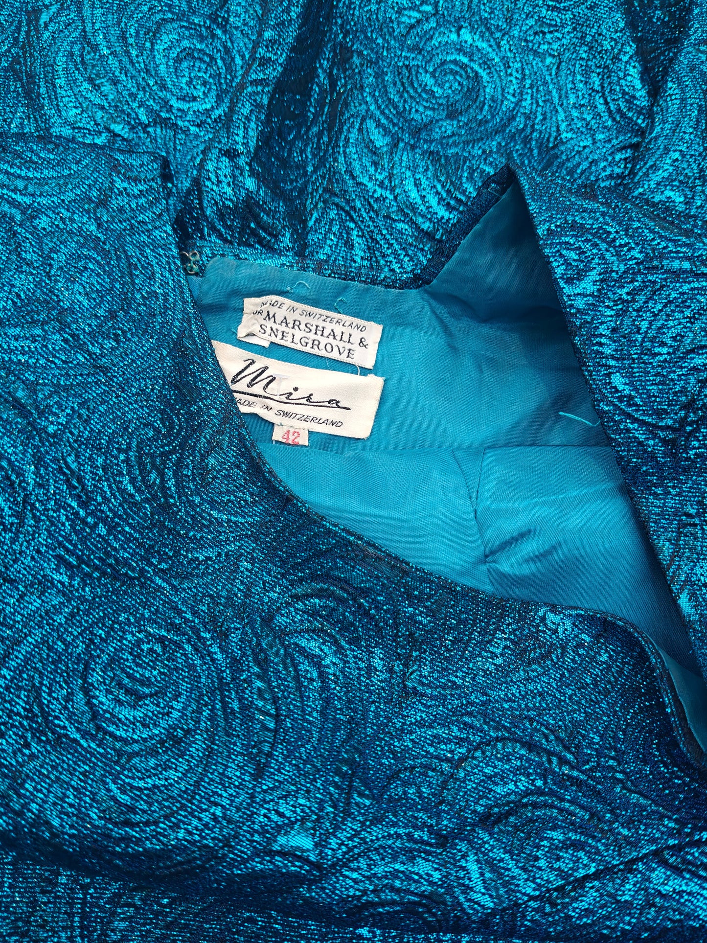 Blue textured fabric with a tag on a matching background