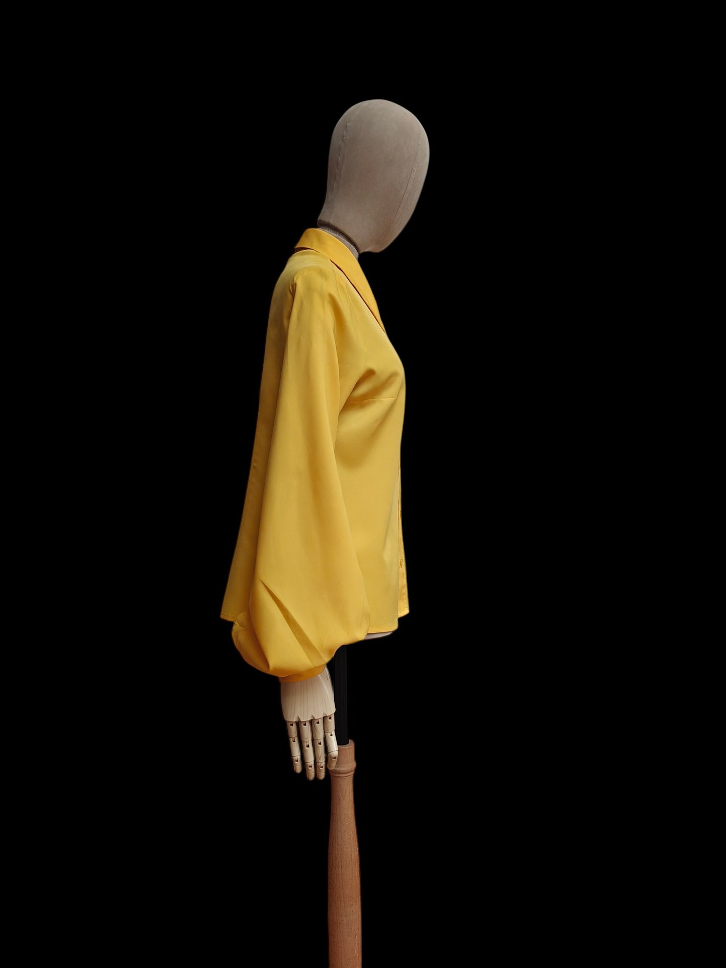 A bright yellow ladies vintage long-sleeve shirt displayed on a mannequin torso against a solid black background.