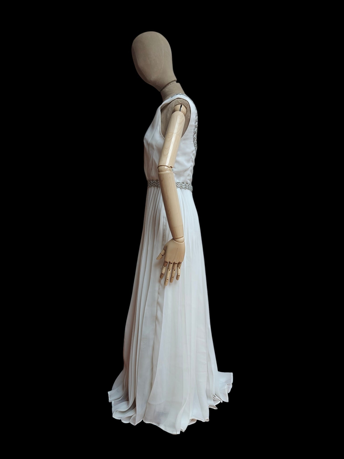 Mannequin wearing a white evening gown on a black background