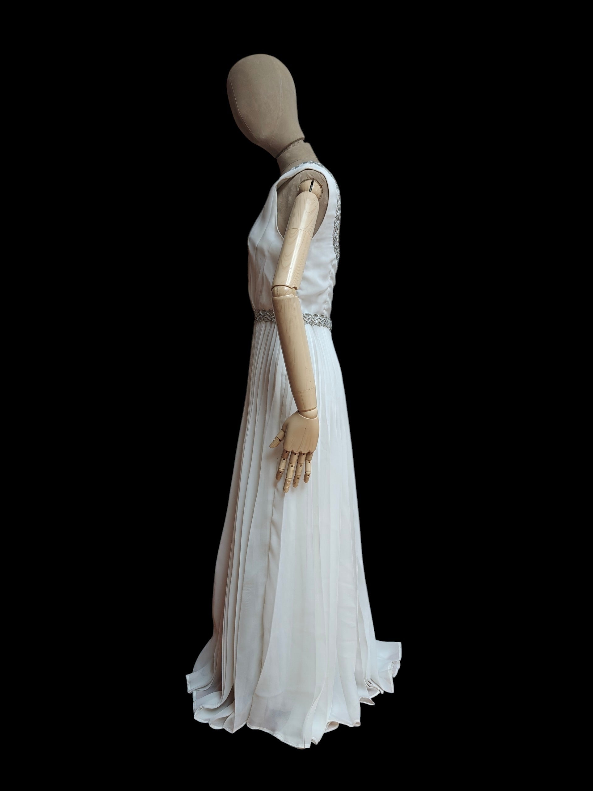 Mannequin wearing a white evening gown on a black background