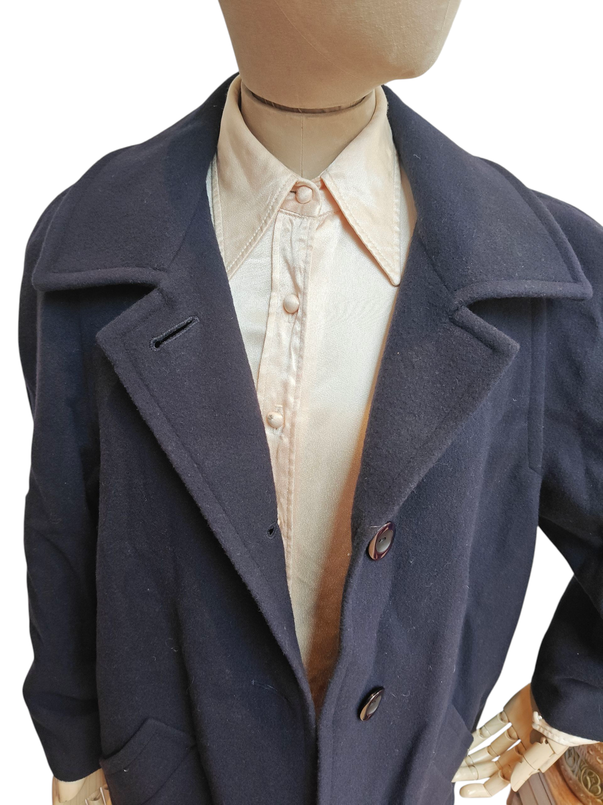 Navy blue coat on a mannequin with a white shirt underneath