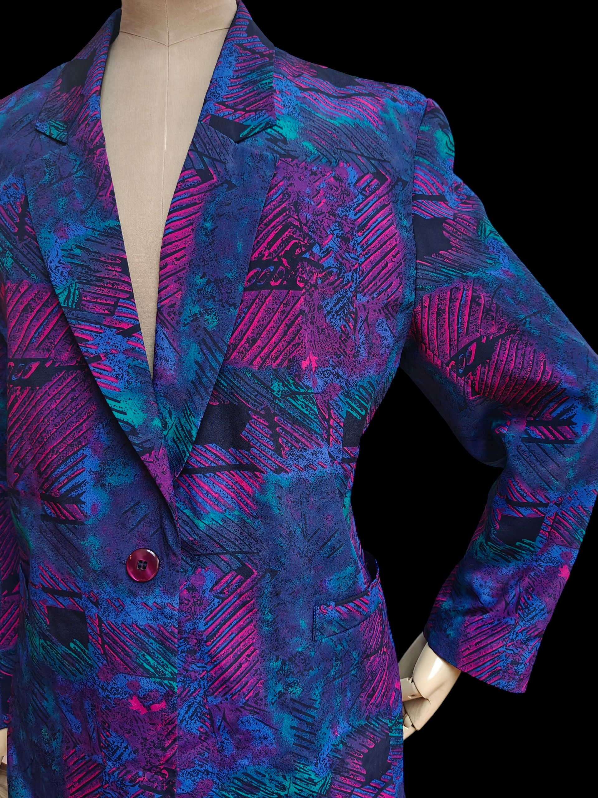 Colorful patterned blazer on a mannequin against a black background