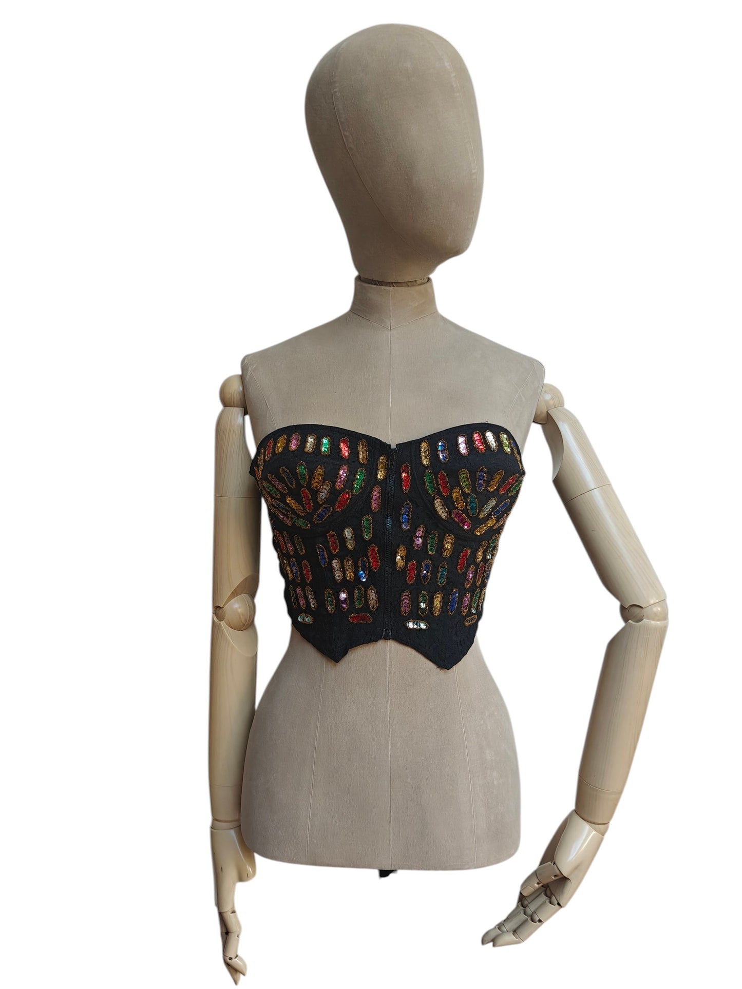 A black strapless corset-style top with colorful embroidered or sequined floral motifs, displayed on a beige mannequin against a plain white background.