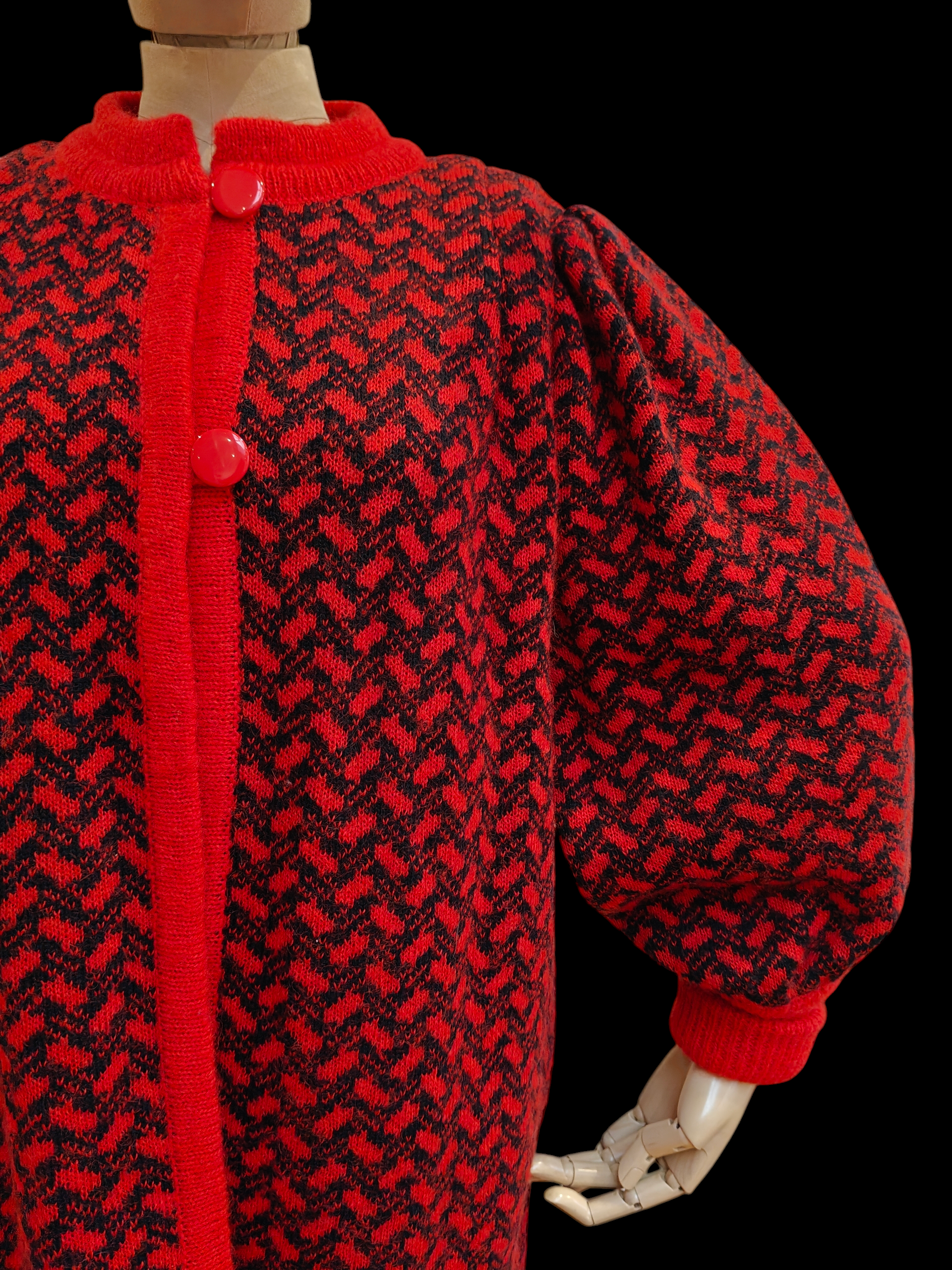 Red and black patterned garment on a mannequin against a black background