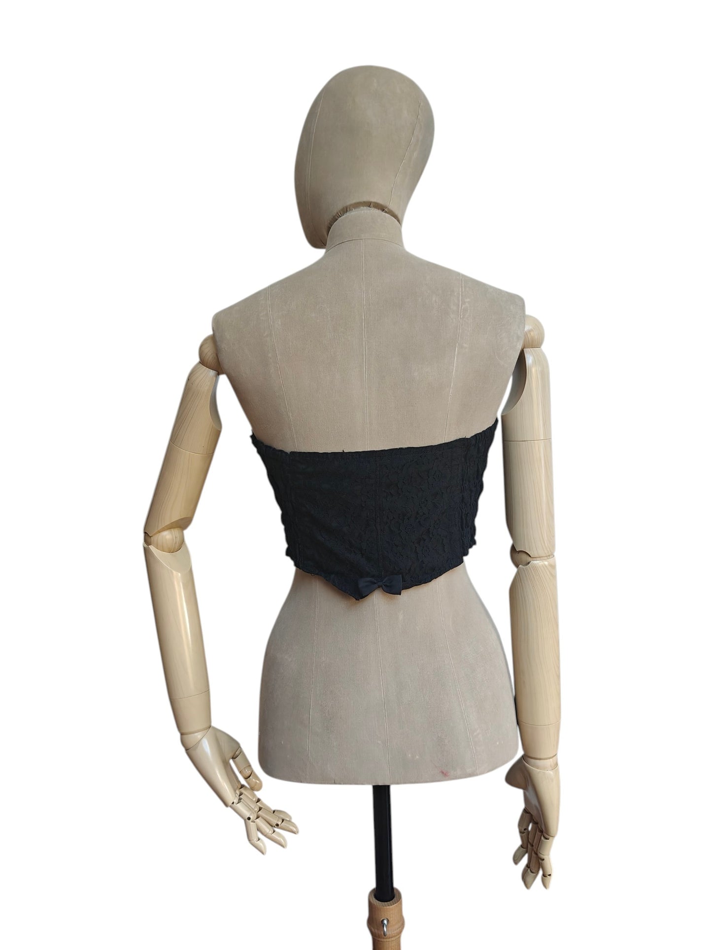 A black sleeveless ruched bustier top displayed on a beige wooden mannequin from the back, set against a plain white background.