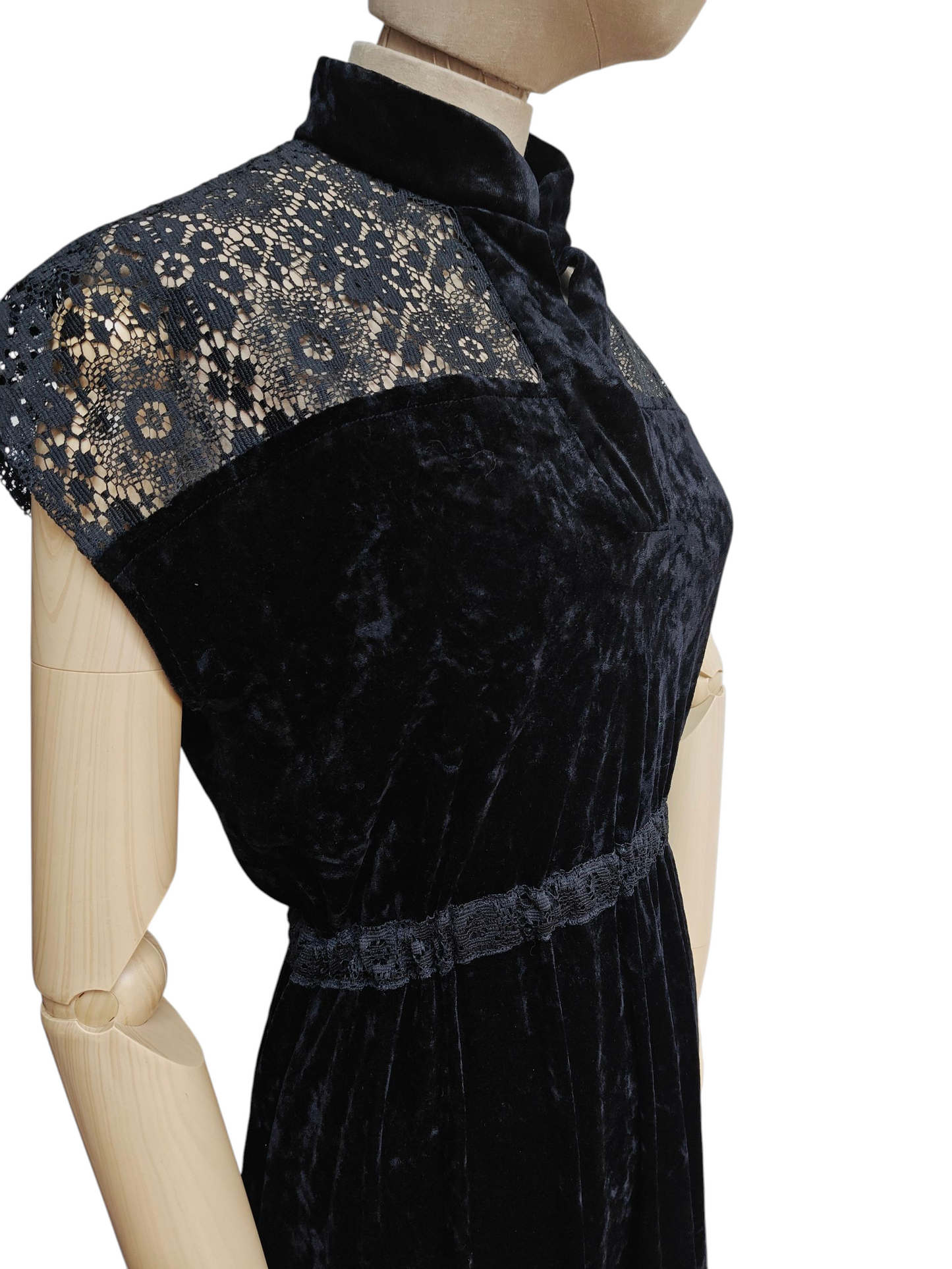 Black velvet dress with lace details on a mannequin against a white background