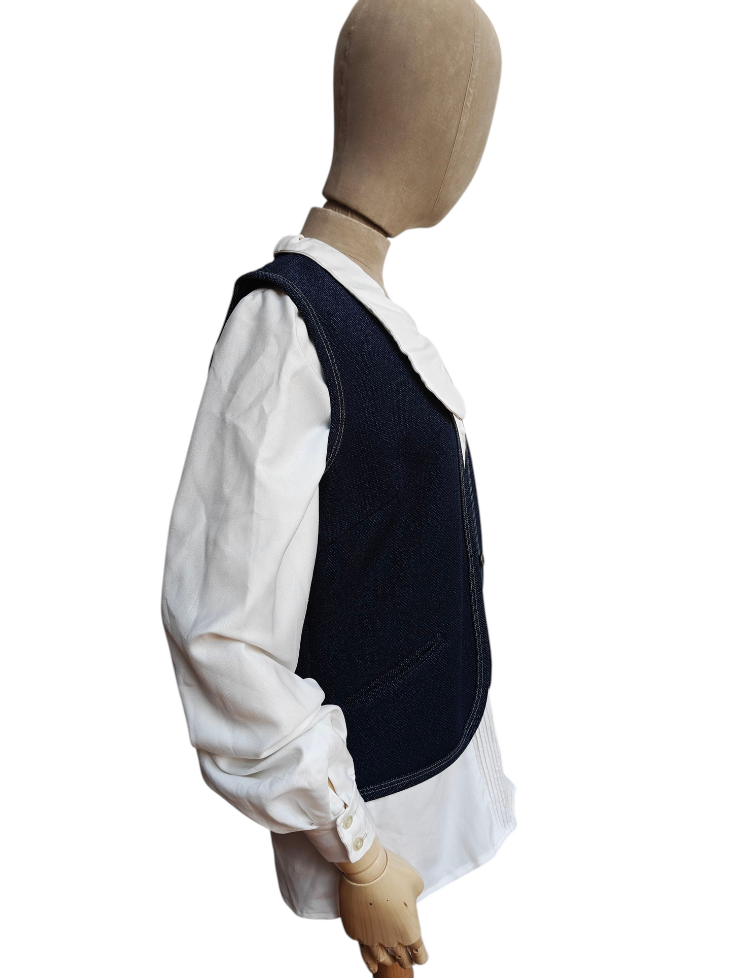 Mannequin wearing a white shirt and dark vest on a white background