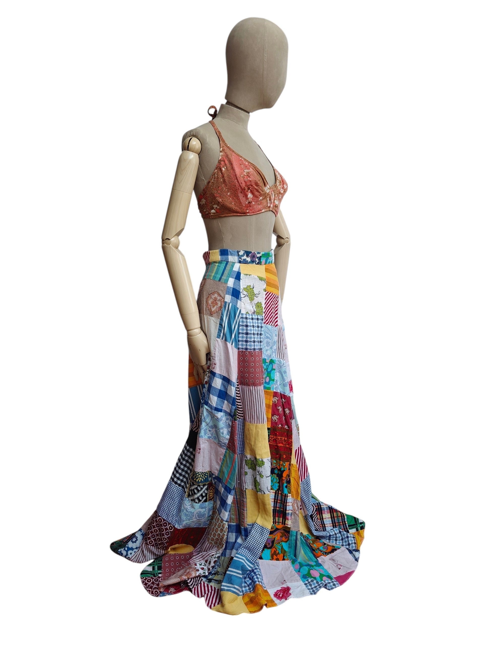 Mannequin wearing a colorful patchwork skirt and peach top on a white background