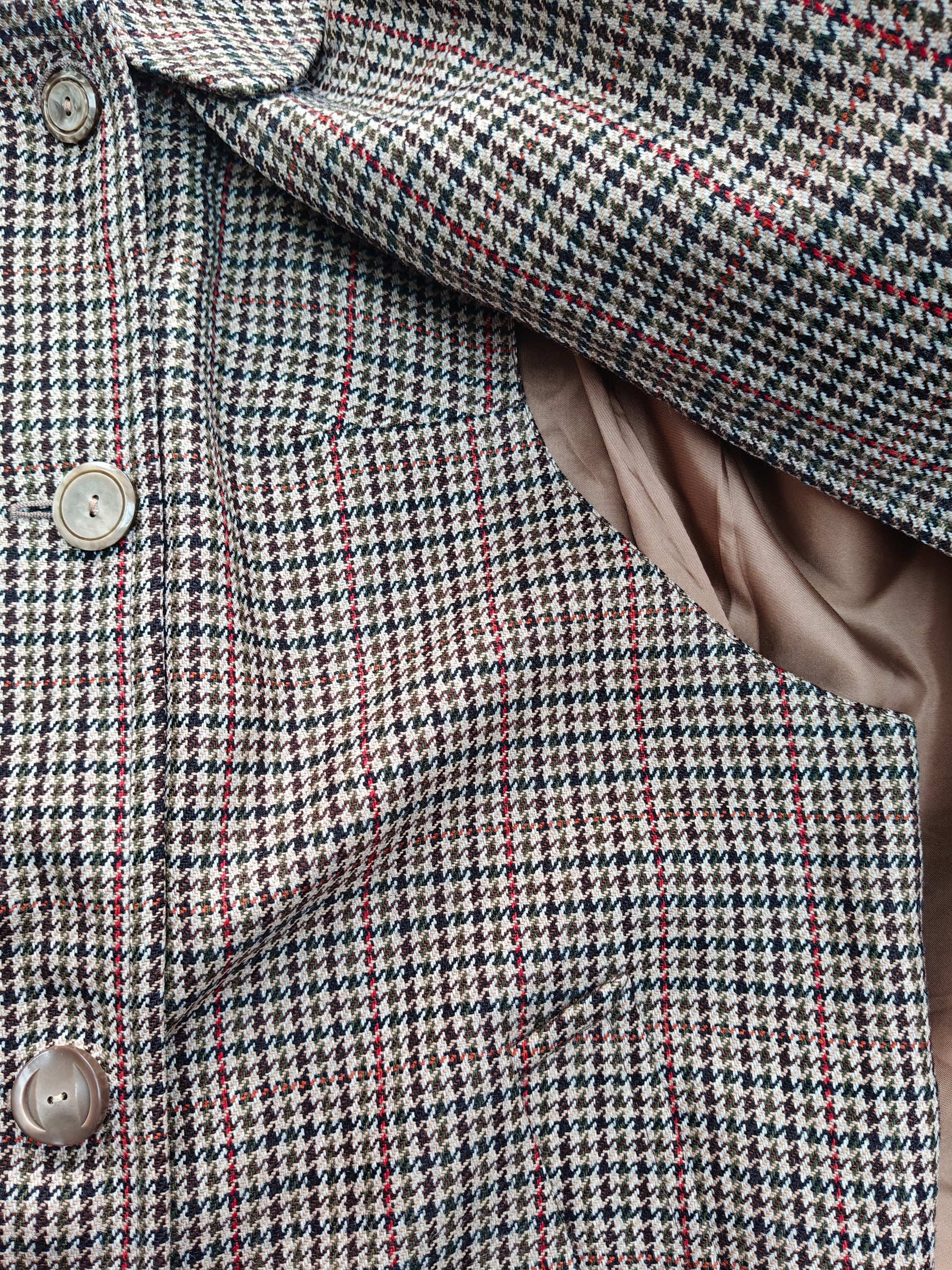 Close-up of a houndstooth patterned coat with buttons.