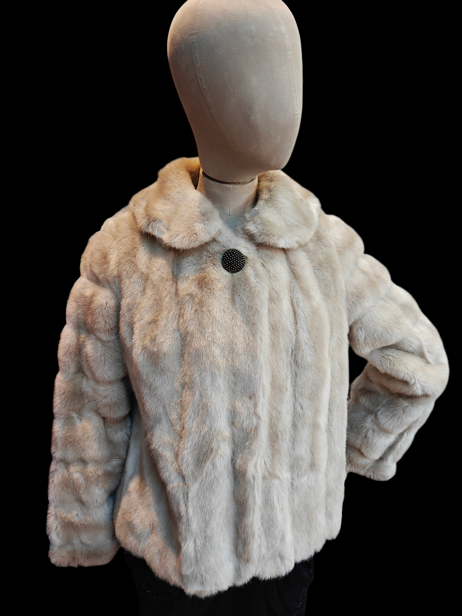 Fur jacket on a mannequin against a black background
