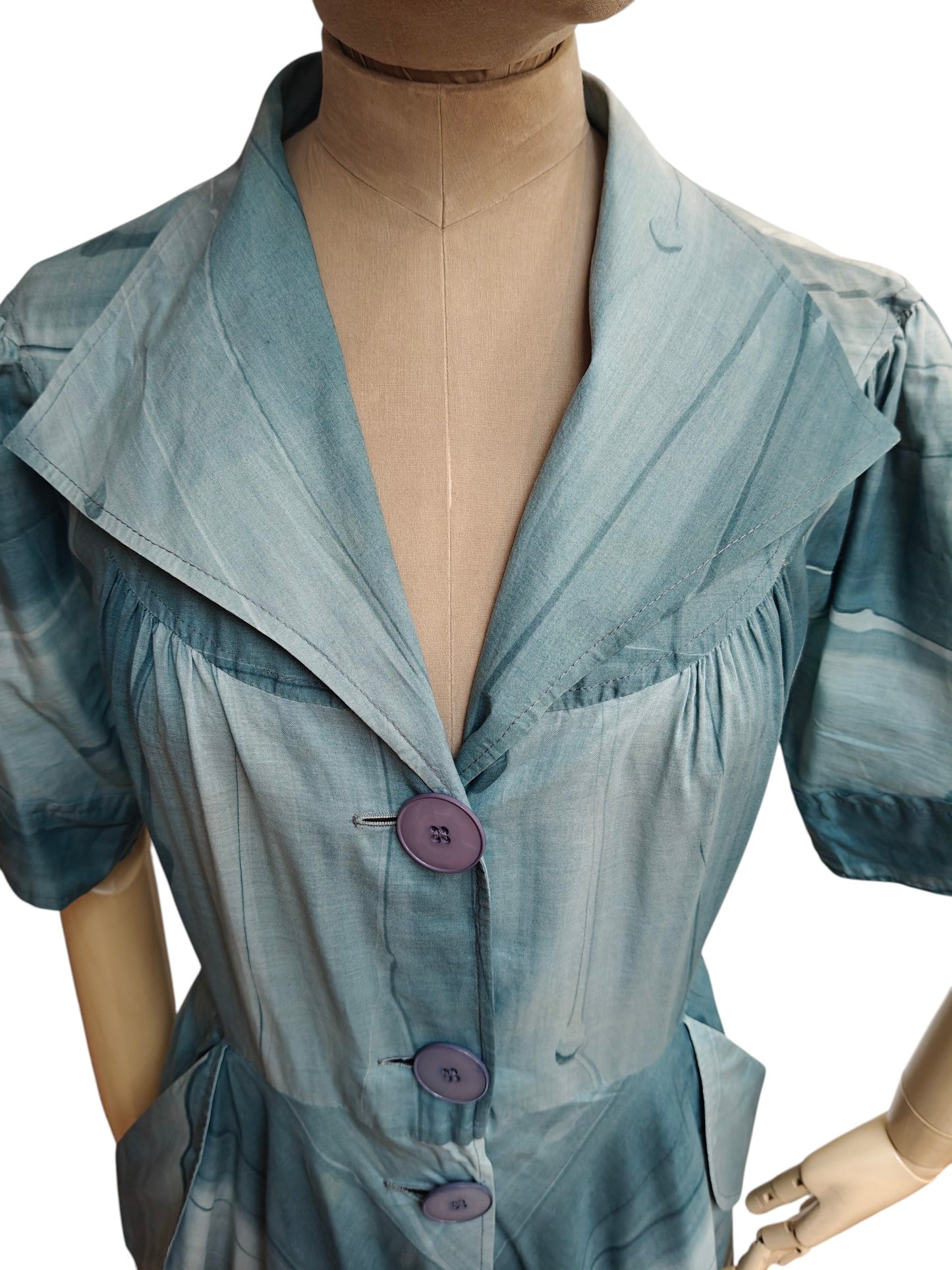 Mannequin wearing a light blue dress with a deep neckline and short sleeves on a white background