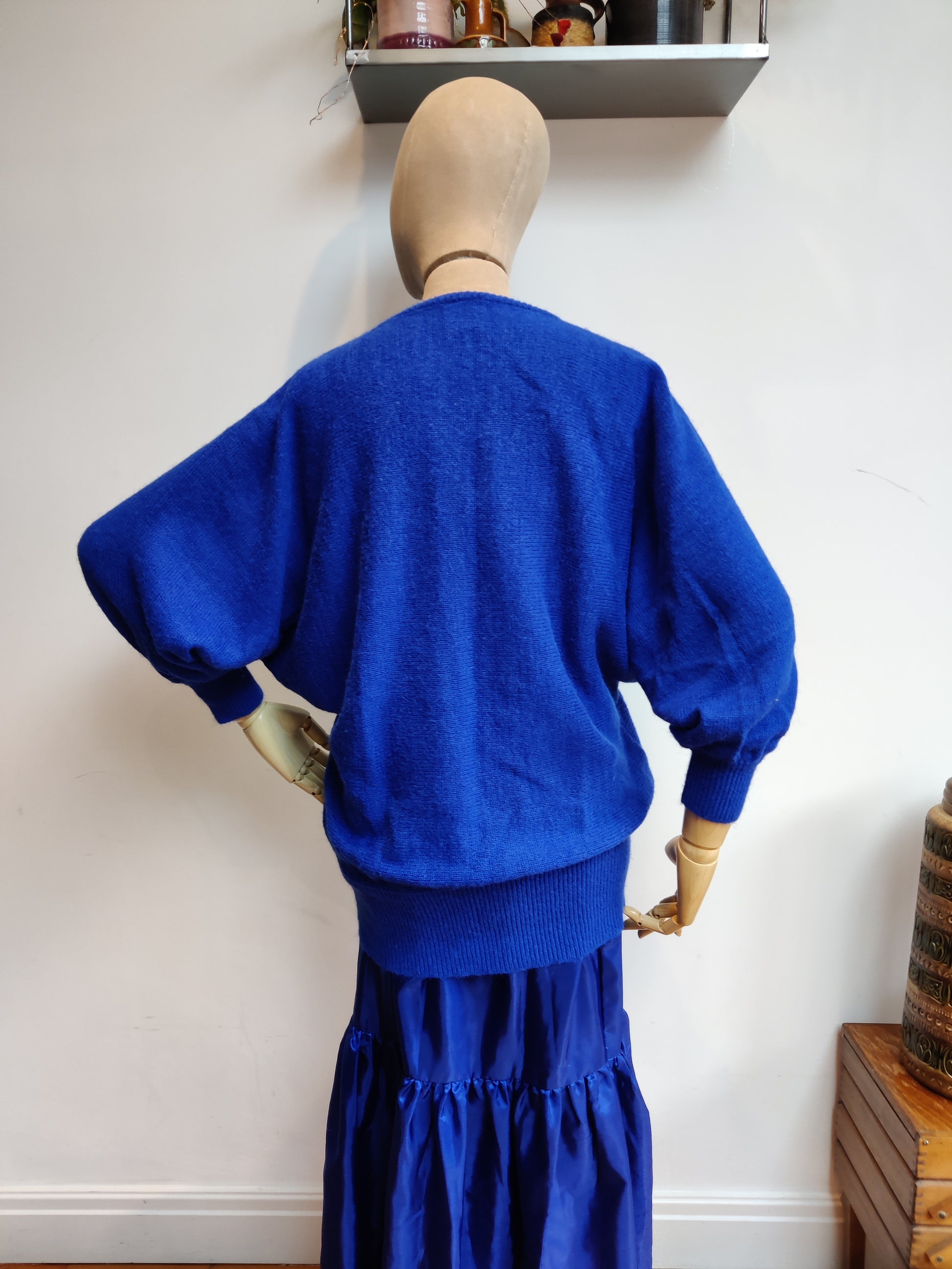 Back view of blue 80s knitted jumper with batwing sleeves