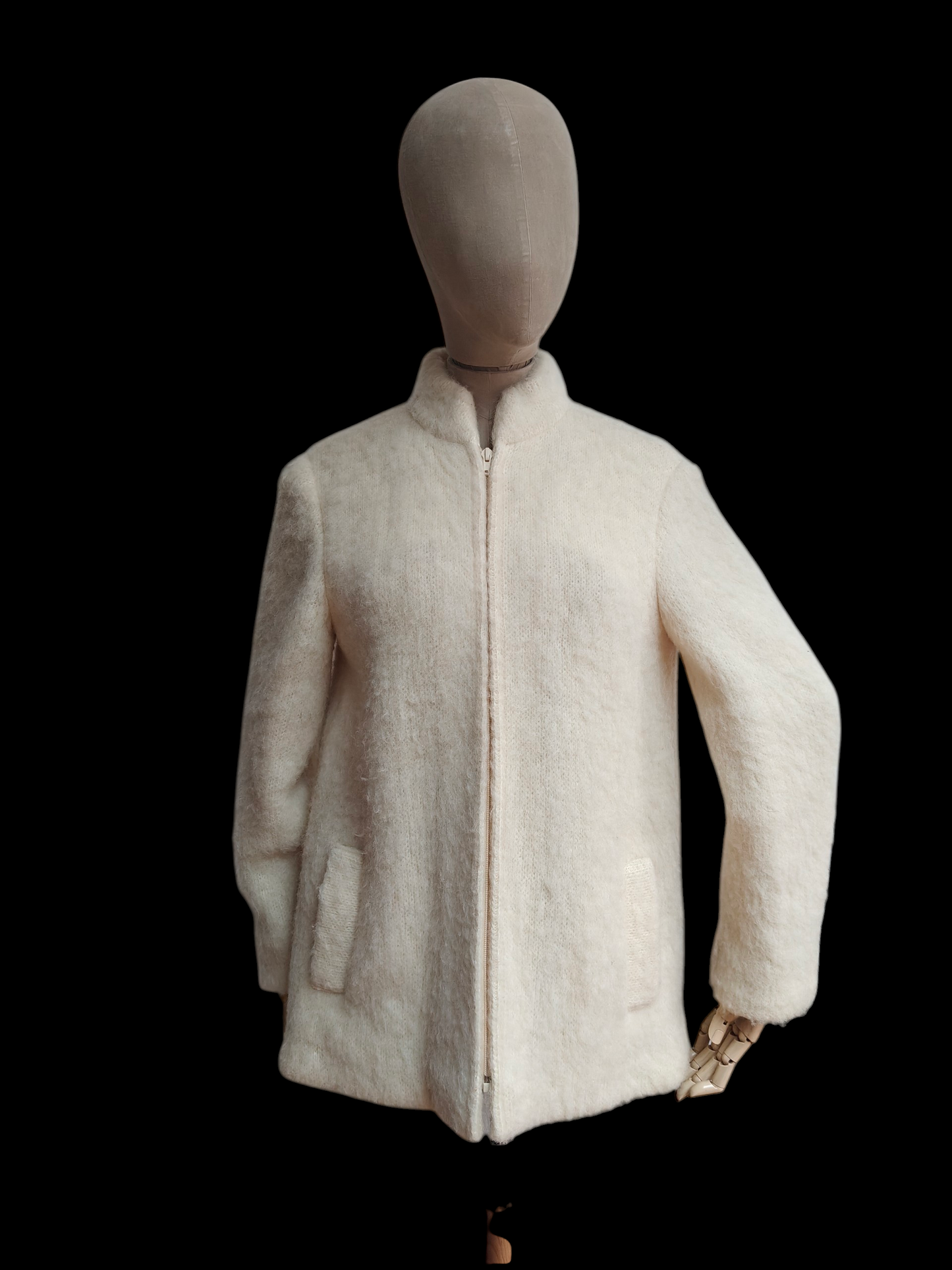 Mannequin wearing a cream-colored jacket on a black background