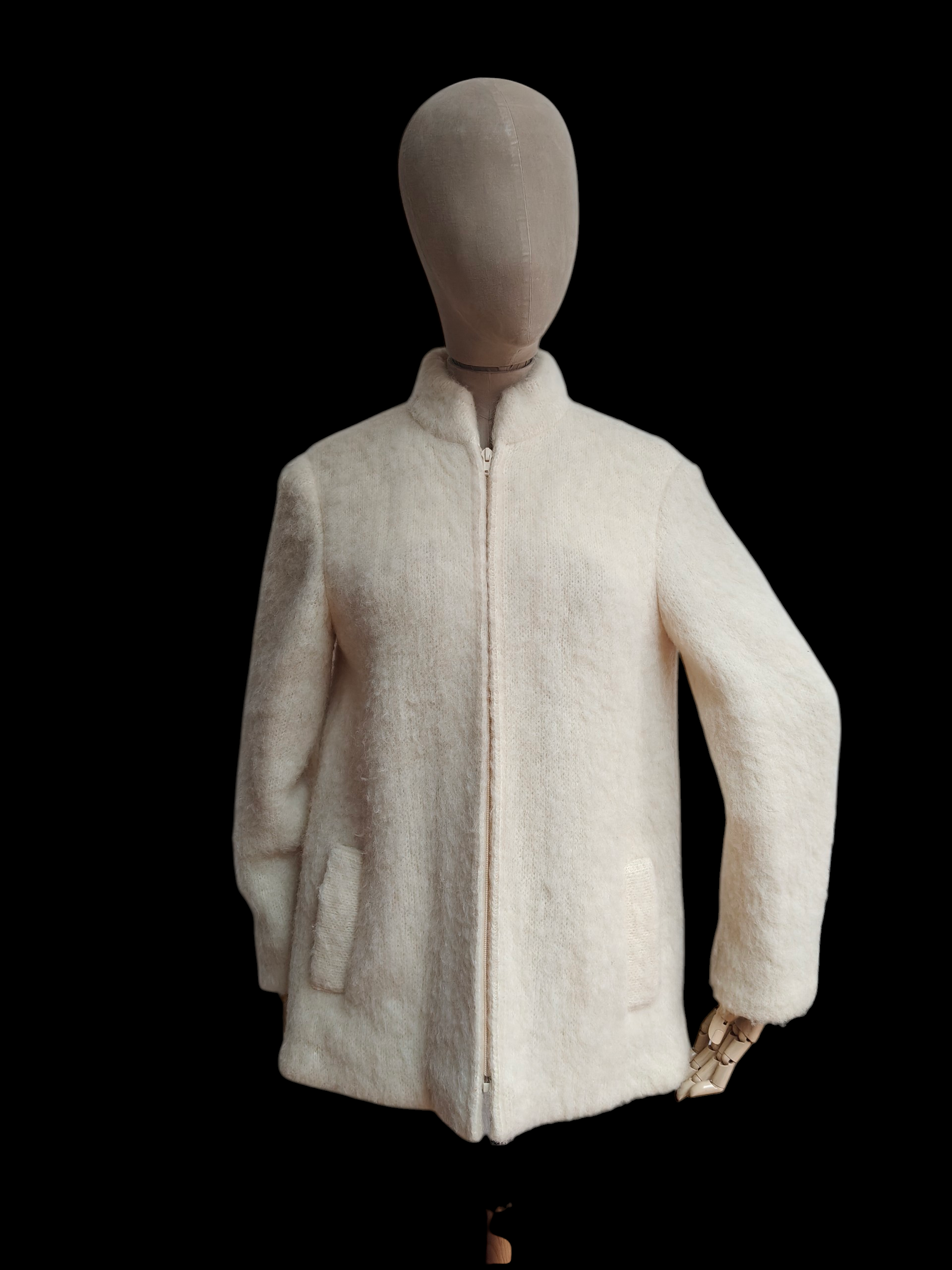 Mannequin wearing a cream-colored jacket on a black background