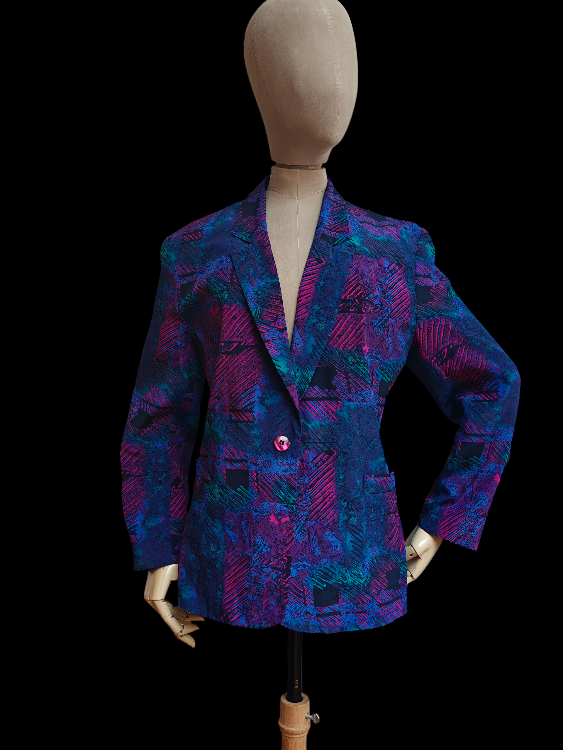 Mannequin wearing a colourful patterned vintage blazer on a black background