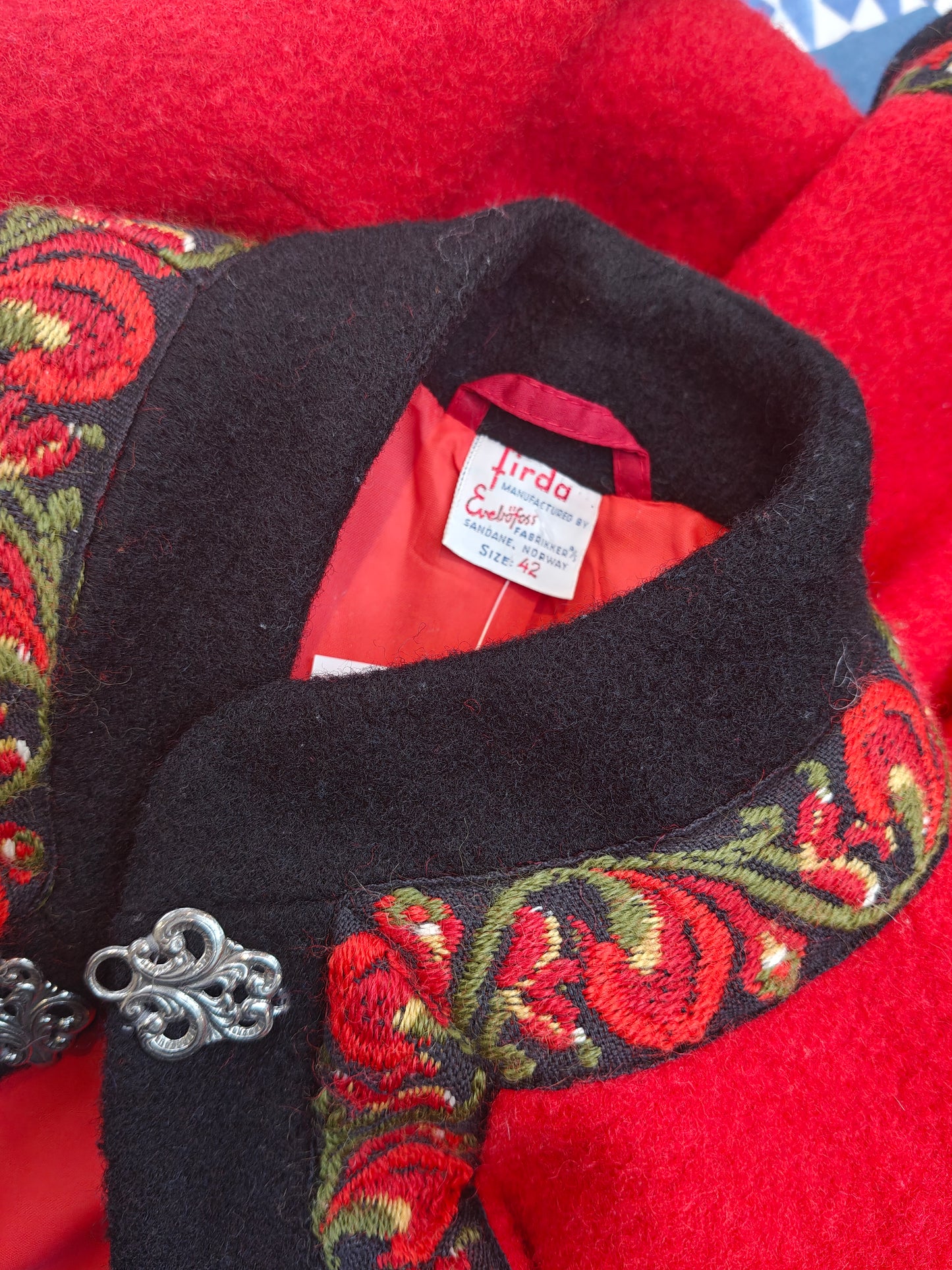 Black collar with red and green floral embroidery on a red background