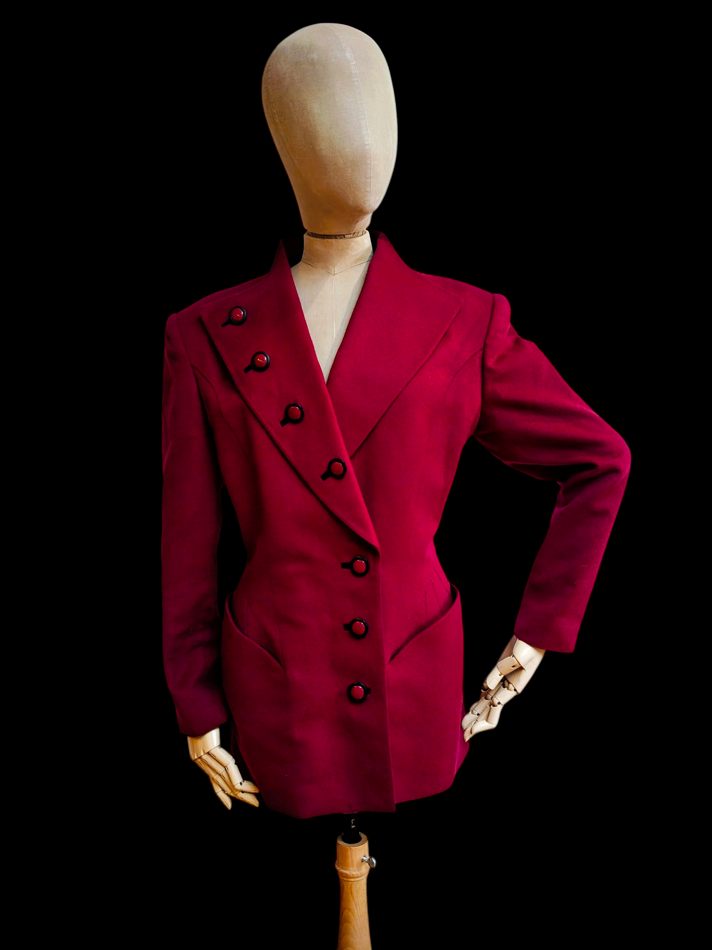 Red blazer on a mannequin against a black background