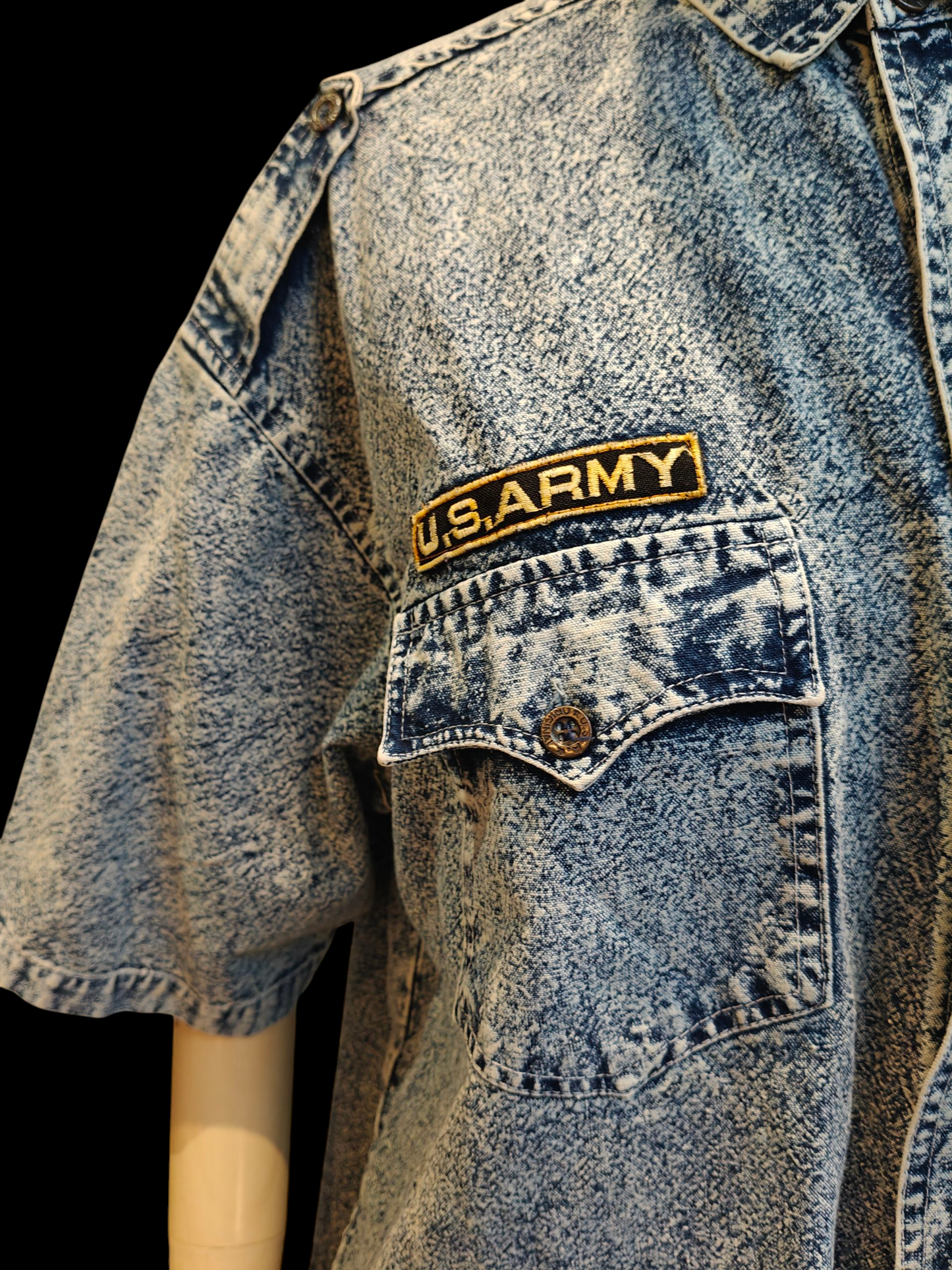 Blue denim shirt with a U.S. Army patch on a black background