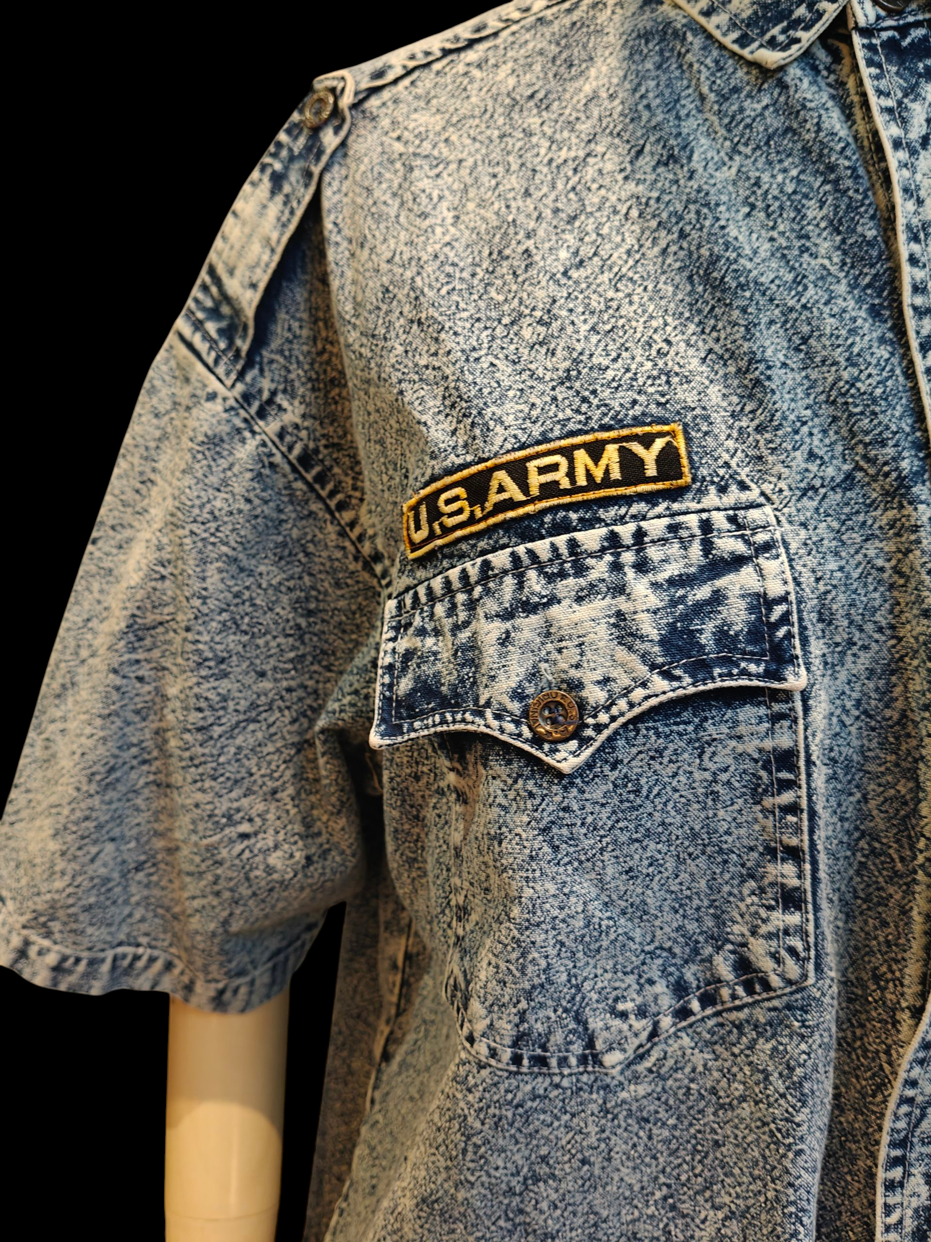 Blue denim shirt with a U.S. Army patch on a black background