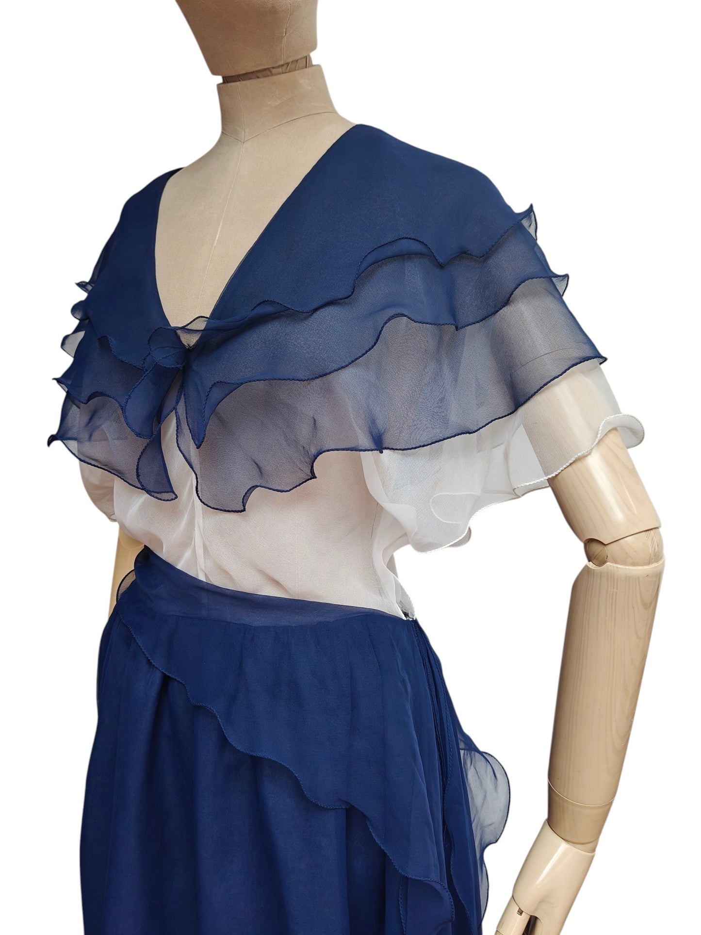 Mannequin wearing a blue and white dress with ruffled details on a white background