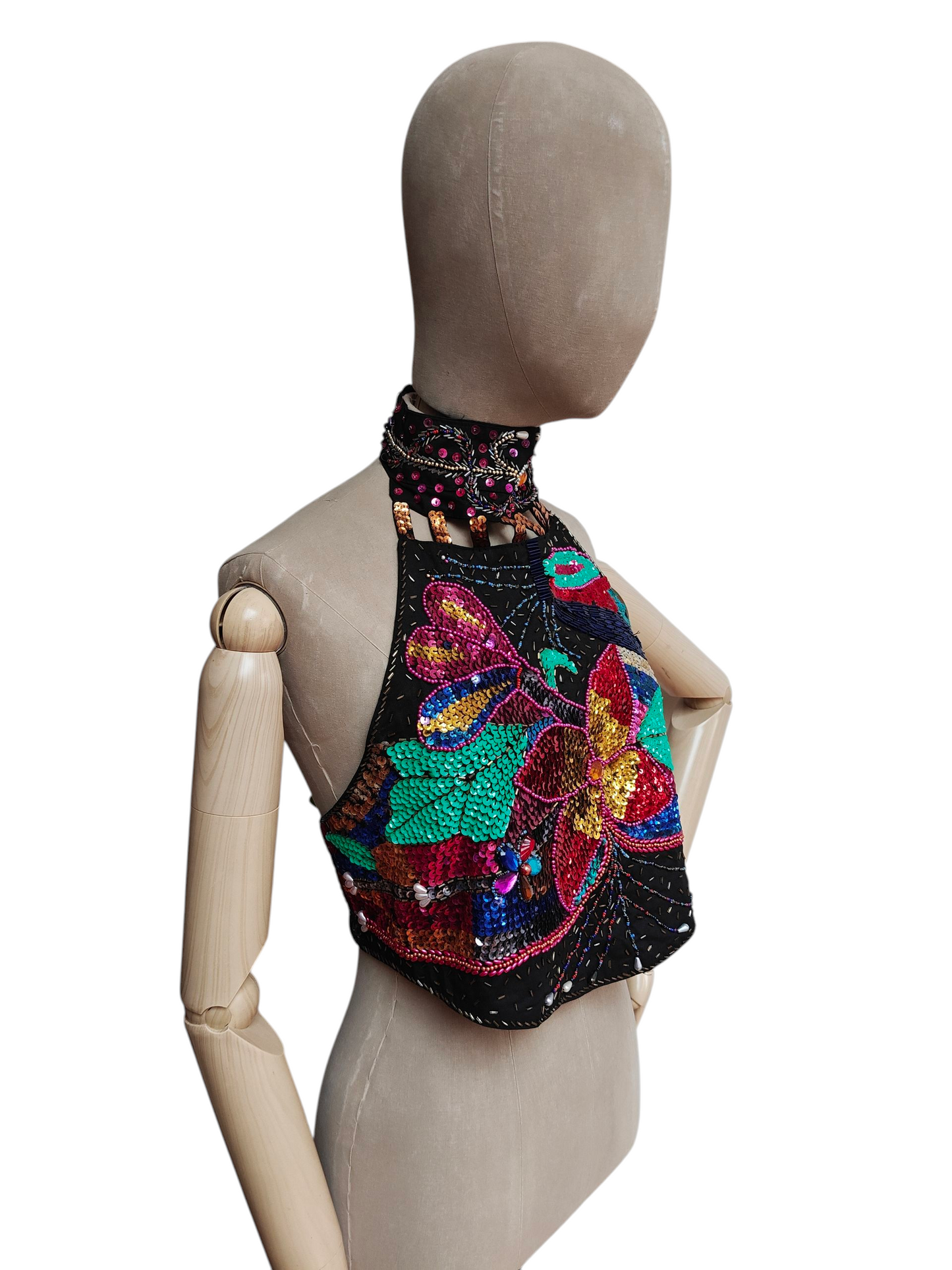 Mannequin wearing a colorful beaded and embroidered top on a white background