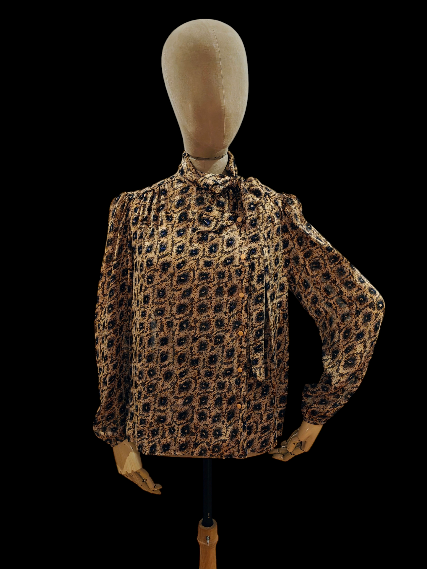 Mannequin wearing a leopard print blouse on a black background