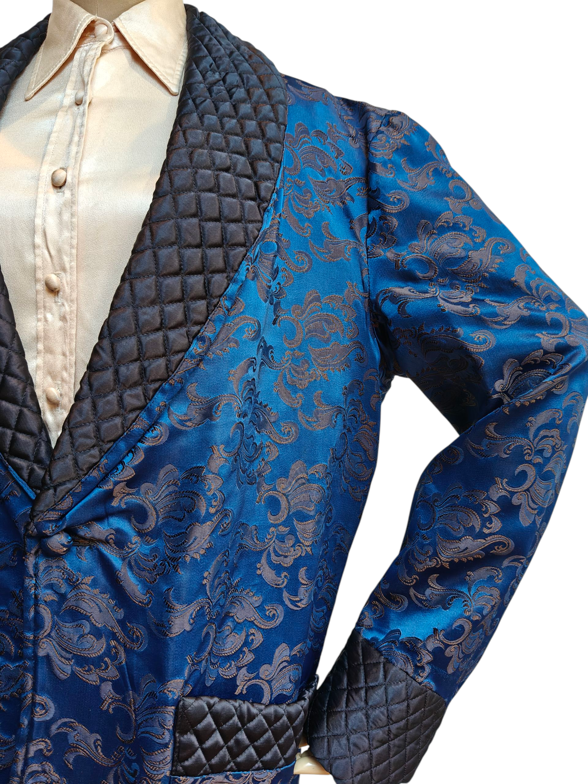 Blue brocade suit with quilted details on a white background