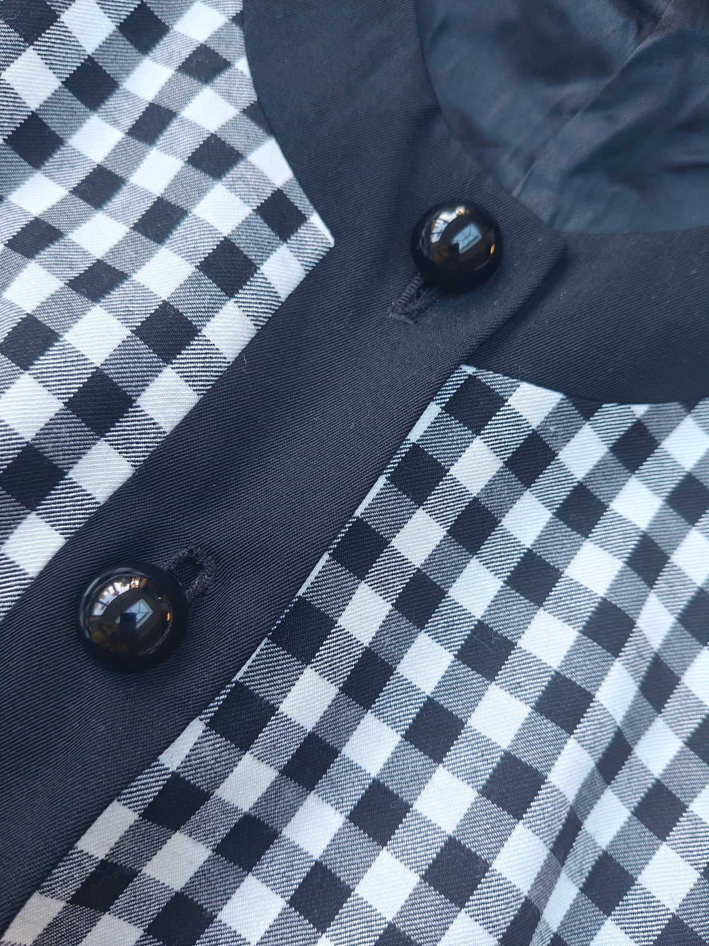 Close-up of a checkered fabric with buttons on a dark background