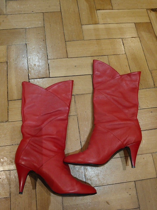 Pair of red high-heeled boots on a wooden floor