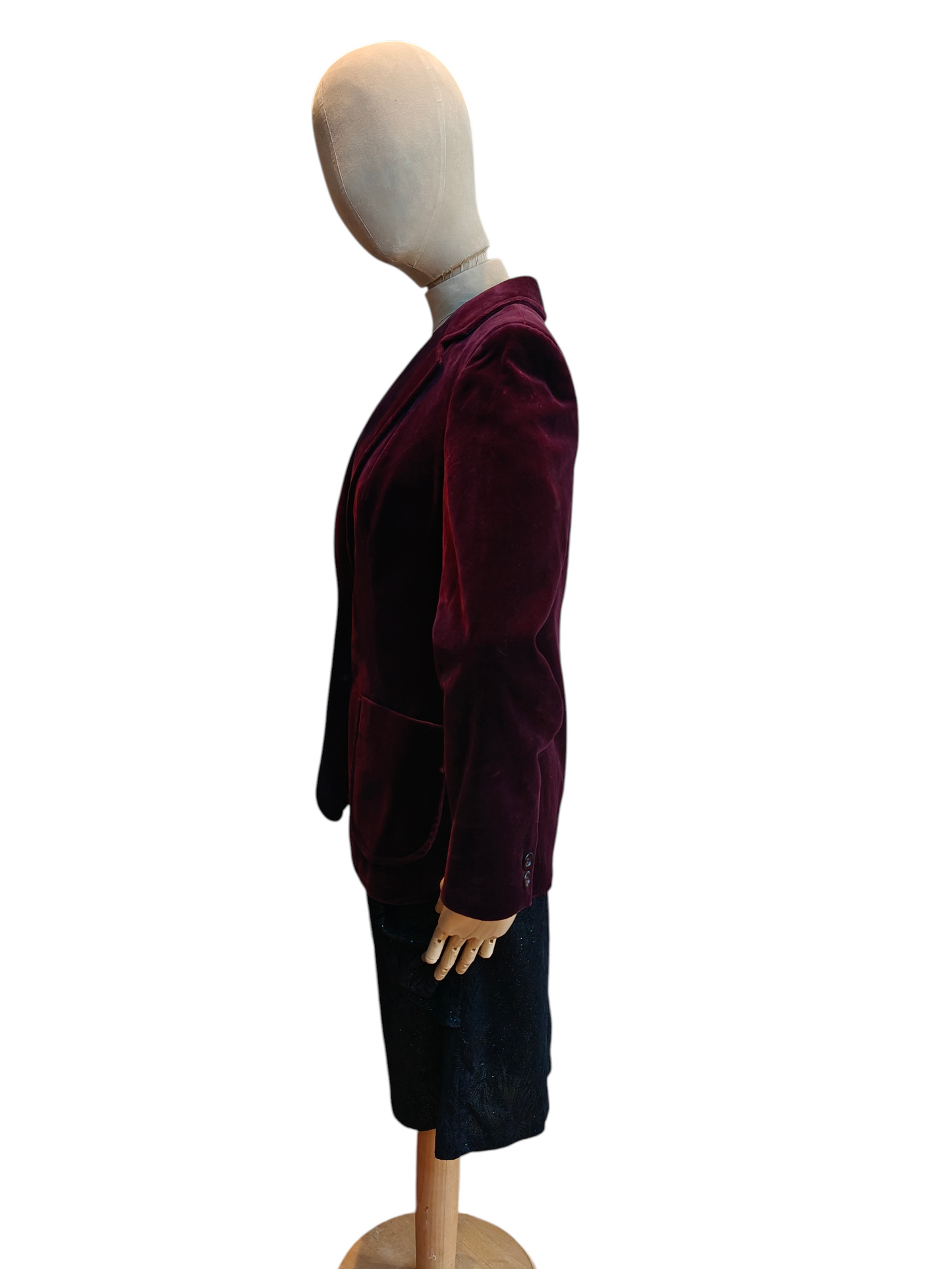 Mannequin wearing a burgundy velvet coat and black skirt on a white background