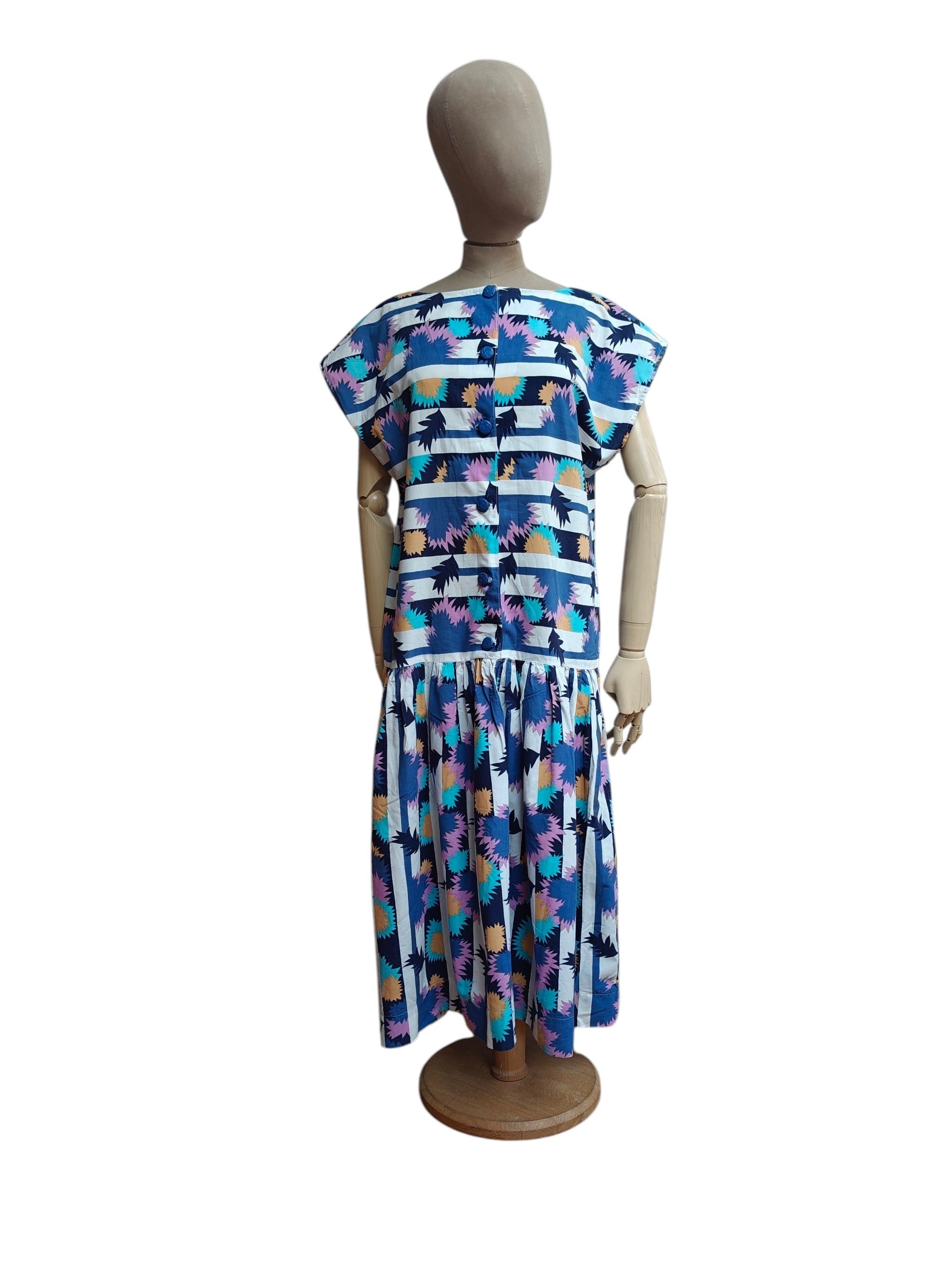 A short-sleeve midi dress with a colorful abstract pattern, displayed on a mannequin from the back against a plain white background.