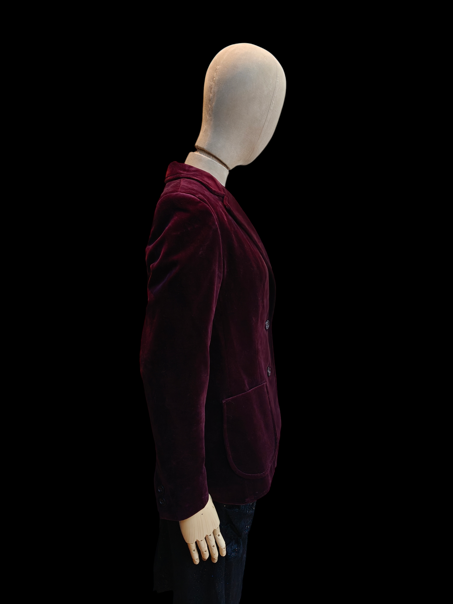 Mannequin wearing a burgundy velvet jacket on a black background